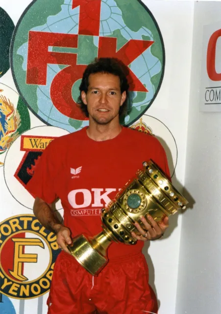 Thomas Dooley in the 1. FC Kaiserslautern OKI jersey with a club trophy.
